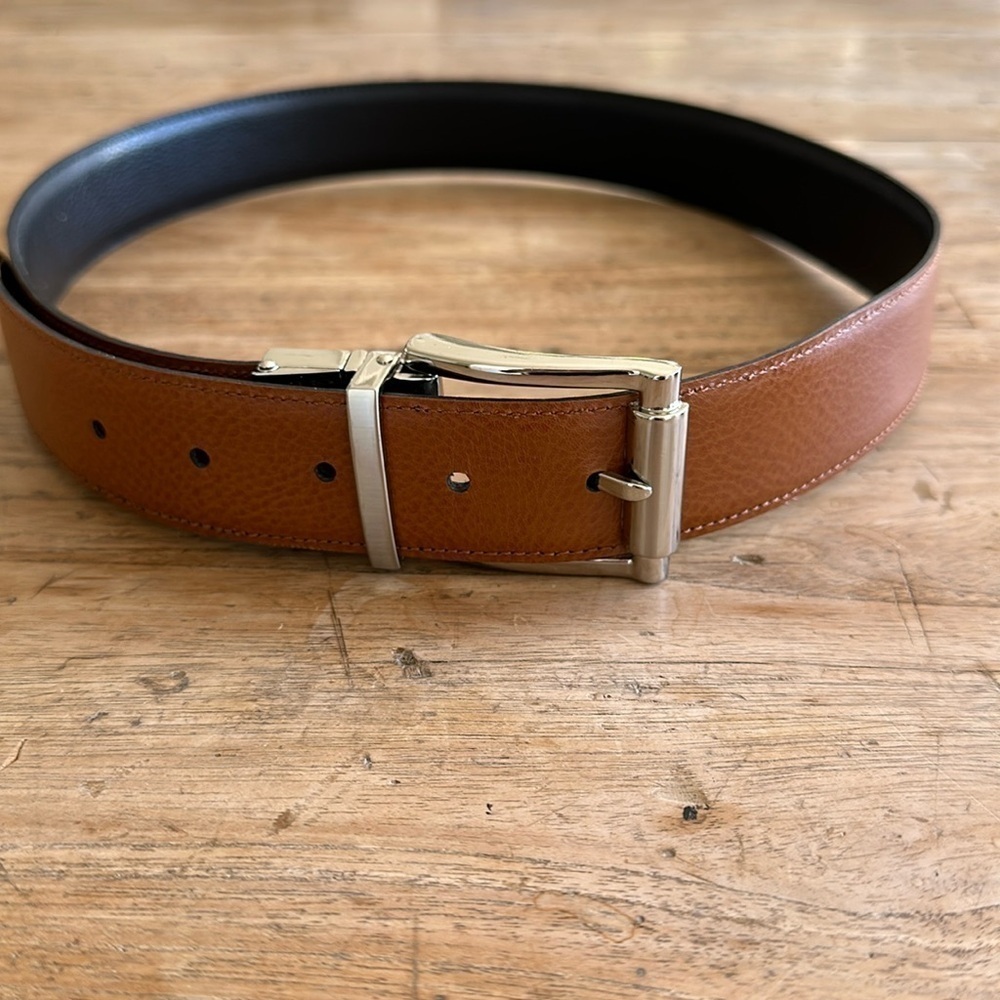 Reversible black and tan belt with silver buckle. Size 32.